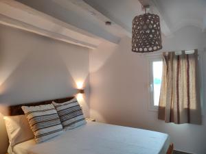 una camera da letto con un letto bianco e una finestra di Mas Midó a Sant Jaume d'Enveja