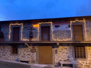 ein Gebäude mit einem Balkon mit Beleuchtung in der Unterkunft Casa Rural del Tormes in Puente del Congosto