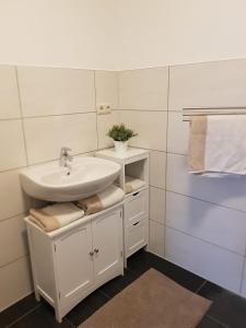a white bathroom with a sink and a mirror at Ferienwohnungen in ausgebauter Scheune mit Ostseenähe in Zarnekow