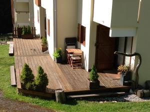 a wooden deck outside of a house with a table and chairs at Appartement la Clusaz avec terrasse sur les pistes de ski in Manigod