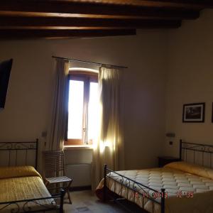 a bedroom with two beds and a window at Corte dei Monaci in Canicattì