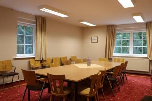 a conference room with a wooden table and chairs at Waldhotel Harz Ilsenburg in Ilsenburg