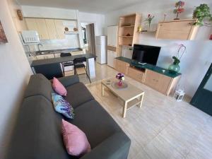 ein Wohnzimmer mit einem Sofa und einem Tisch in der Unterkunft CASA MERY in Puerto del Carmen