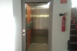 a stainless steel refrigerator with a fire extinguisher on the wall at Casa de Larios in Estepa