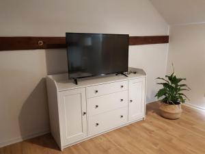a tv on top of a white dresser in a room at Ferienwohnungen in ausgebauter Scheune mit Ostseenähe in Zarnekow