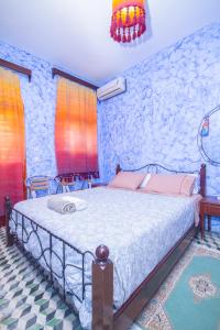 1 dormitorio con cama y pared de piedra en Hotel TOURAGHINE, en Chefchaouen