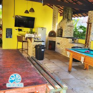 eine Terrasse mit einem Billardtisch und einem TV in der Unterkunft Chalé das Conchas in Pipa