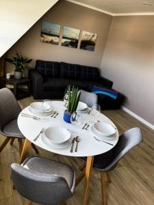 a white dining room table with chairs and a couch at Op'n Dörp Apartment in Barsbek