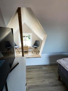 a attic room with two chairs and a window at Op'n Dörp Apartment in Barsbek