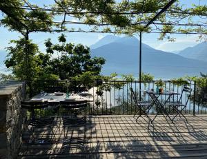 a table and chairs on a patio with a view of the ocean at Agriturismo Treterre in Pianello Del Lario