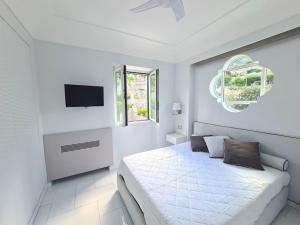 a white bedroom with a bed and a window at La Spiga in Capri