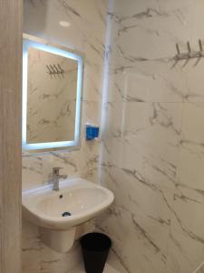 a white bathroom with a sink and a mirror at (41)m luxury room royal view near all services in Ash Shumaysānī