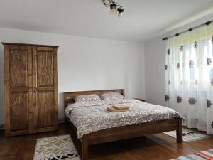 a bedroom with a bed and a wooden cabinet at La mosu Rovin 