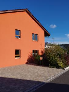 una casa naranja con una entrada delante de ella en RK Apartments Birnbaum en Gerhardshofen