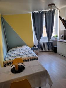 1 dormitorio con 1 cama y 2 ventanas grandes en Voyage de lumière - Dormir Comme à la maison -, en Châteaubriant
