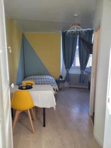 Habitación con cama, mesa y ventana en Voyage de lumière - Dormir Comme à la maison -, en Châteaubriant
