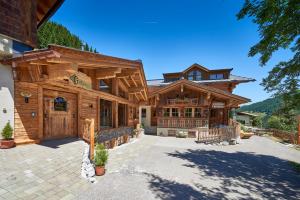 une grande maison en bois avec une allée. dans l'établissement Highking Chalet Grünegg, à Dienten am Hochkönig