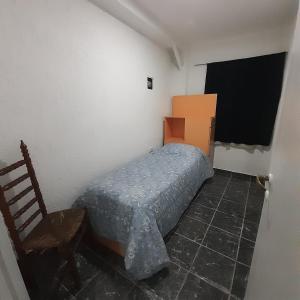 1 dormitorio pequeño con 1 cama y 1 silla en Alojamiento en Mendoza en Godoy Cruz