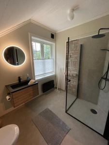 y baño con ducha y lavamanos. en Nice apartment close to the sea with parking and garden, en Arendal