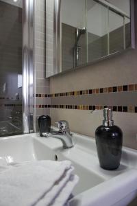 a bathroom sink with a black soap dispenser on it at Gioia In Collina in Torrevecchia Teatina