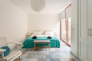 a bedroom with a bed with a green blanket at Quinta de Fermil - Casas in Vouzela +119 photos