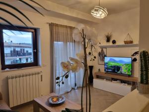 uma sala de estar com um vaso de flores e uma televisão em GIULIA'S HOUSE - Natura & Avventura em Castel di Sangro