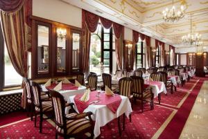 Hotel Excelsior في ماريانسكي لازني: صف من الطاولات والكراسي في المطعم