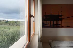 um quarto com uma janela com vista para um campo em Gioia In Collina em Torrevecchia Teatina
