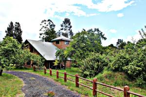 a wooden house with a fence next to a dirt road at Cabanas de Monasterio in Puerto Clocker