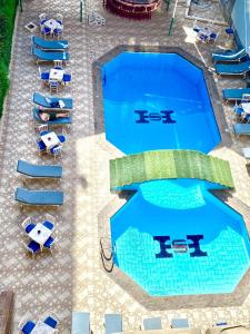 an overhead view of a swimming pool with chairs and umbrellas at Shady Hotel Luxor in Luxor
