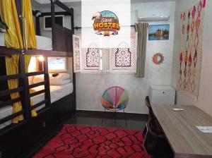 馬拉喀什的住宿－Stork Marrakech Luxury Hostel，一间卧室配有一张双层床、一张桌子和一把椅子