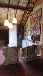 two wicker chairs sitting in a room with a table at Pousada Villa Mariposa in Beberibe