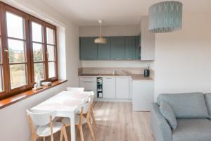 eine Küche und ein Wohnzimmer mit Tisch und Stühlen in der Unterkunft Apartmán Sjezdovka in Kašperské Hory