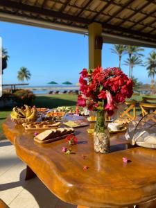 uma mesa com pratos de comida e flores em Villa Garcez em Jaguaripe
