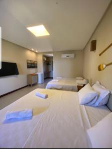 um quarto com 2 camas e uma televisão de ecrã plano em Villa Garcez em Jaguaripe