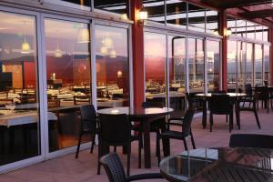 um restaurante com mesas, cadeiras e janelas em Hotel Da Montanha em Pedr�g�o Pequeno