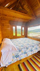 a large bed in a room with windows at Villa Angela Glamping & Tiny Houses in Paipa