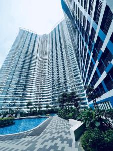 un grand bâtiment avec une piscine en face dans l'établissement Air Residences Makati, à Manille