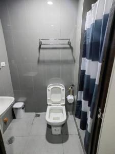 La petite salle de bains est pourvue de toilettes et d'un lavabo. dans l'établissement Air Residences Makati, à Manille