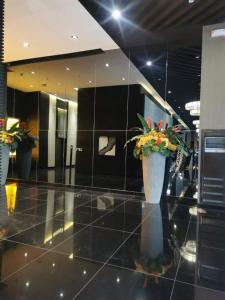 - un hall avec deux vases avec des fleurs dans l'établissement Air Residences Makati, à Manille