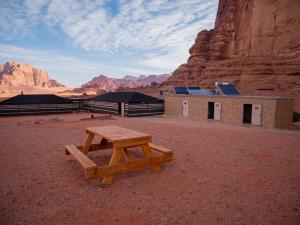 stół piknikowy i budynek na pustyni w obiekcie Desert Mars Camp & Tours w mieście Wadi Rum