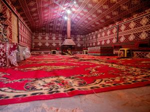 瓦迪拉姆的住宿－Desert Mars Camp & Tours，一间大房间,地板上铺有红色地毯