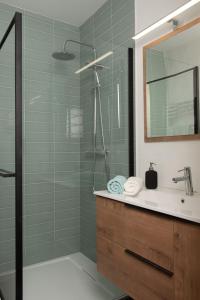 a bathroom with a shower with a sink and a mirror at Charmant Studio tout confort au Brévent-Chamonix in Chamonix