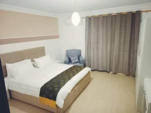 a bedroom with a large bed and a chair at Pomegranate Tree in Wadi Musa