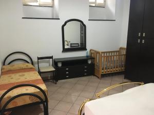 Zimmer mit 2 Betten, einem Spiegel und einem Kinderbett in der Unterkunft casa 102 in Finale Ligure