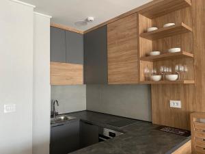 a kitchen with wooden cabinets and a sink at Apartman 207 in Zlatibor