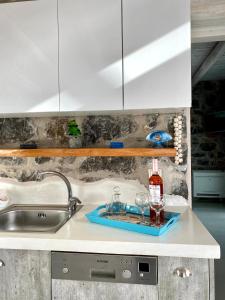 a kitchen sink with two glasses and a bottle of wine at Stelani Villas & Suites in Kalamaki