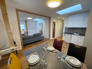 a dining room with a table and a kitchen at SCHNYDER'S HOME - Rosenappartement in Rapperswil-Jona