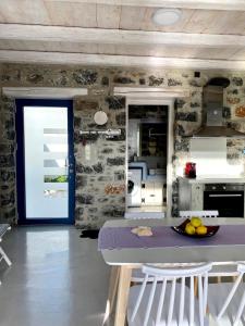 a kitchen with a table with a bowl of fruit on it at Stelani Villas & Suites in Kalamaki