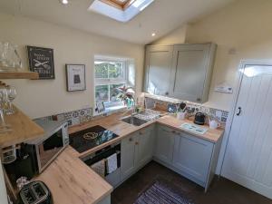 a kitchen with a sink and a counter top at Pinfold Holiday Cottage in Skipton
